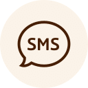 A circular icon with a beige background features a brown speech bubble containing the letters "SMS" in the center, symbolizing quick communication between veterinarians and their clients.